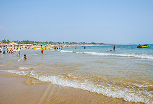 Baga Beach shoreline with visitors, gentle waves, and water activities