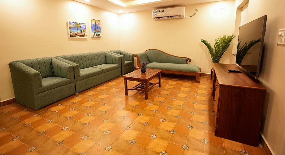 Spacious Goa villa living room with sofa, TV, and air conditioning
