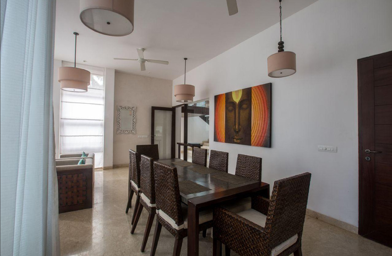 Stylish dining area with woven chairs and large wall artwork