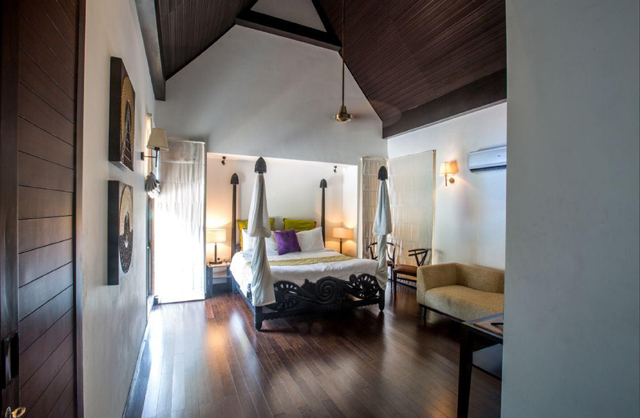 Elegant master bedroom with high wooden ceiling and carved bed