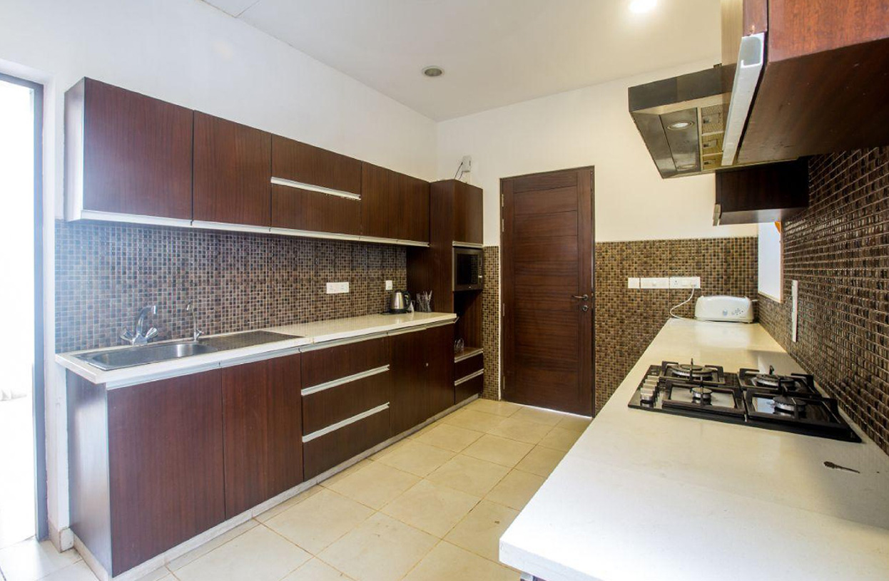 Modern kitchen with wooden cabinets, mosaic backsplash, and built-in appliances