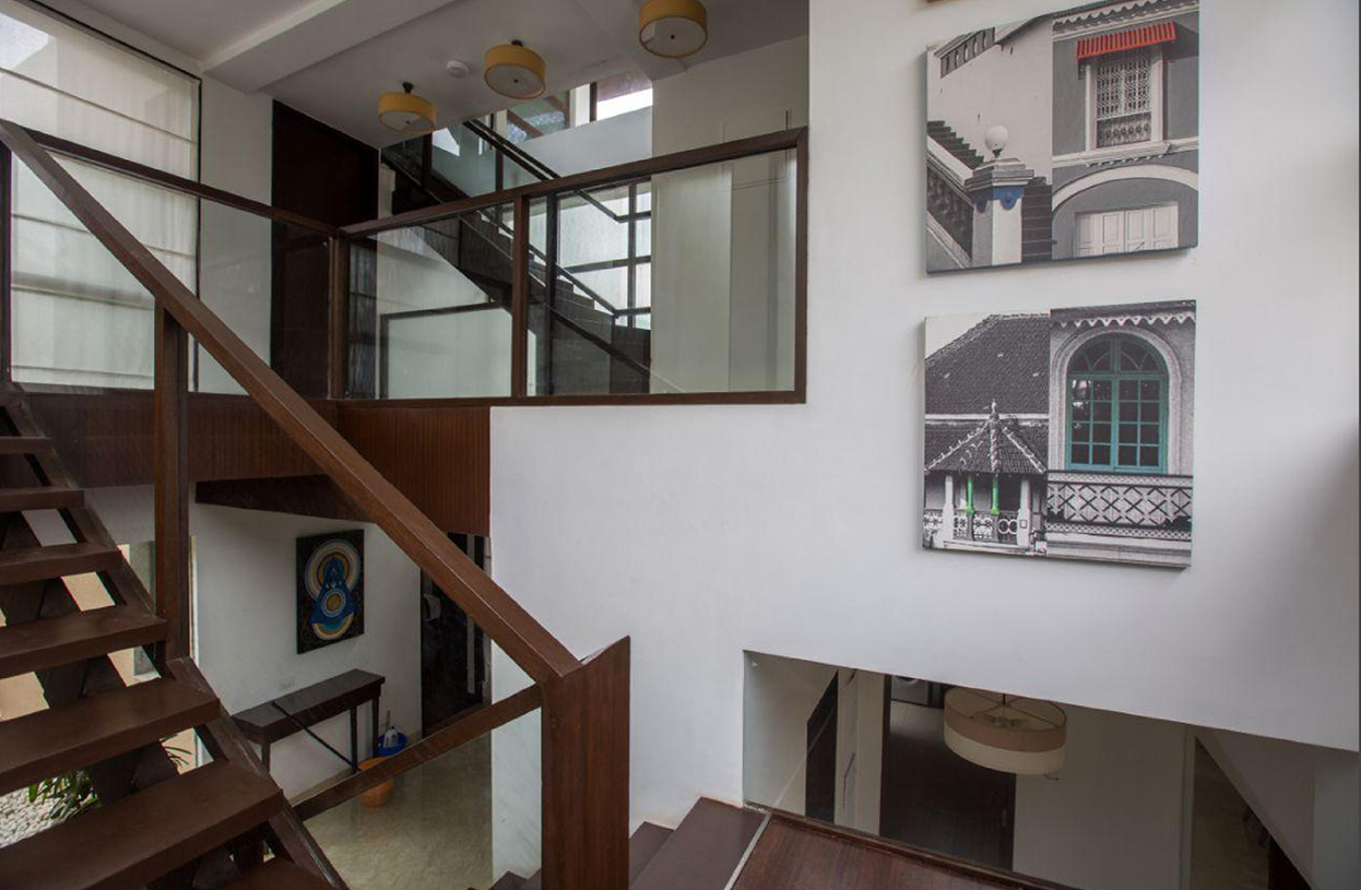 Contemporary staircase with glass railing and artistic gallery wall