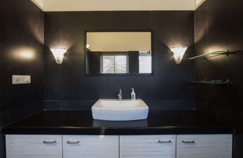 Bathroom sink with mirror, wall lights and storage cabinets