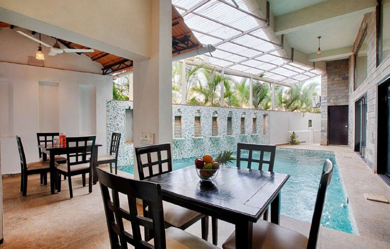 Villa dining area beside swimming pool with outdoor seating