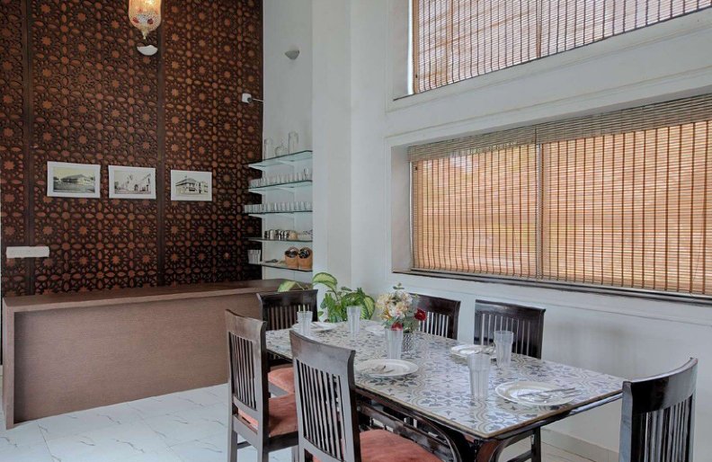 Villa dining room with wooden table, chairs and decorative wall