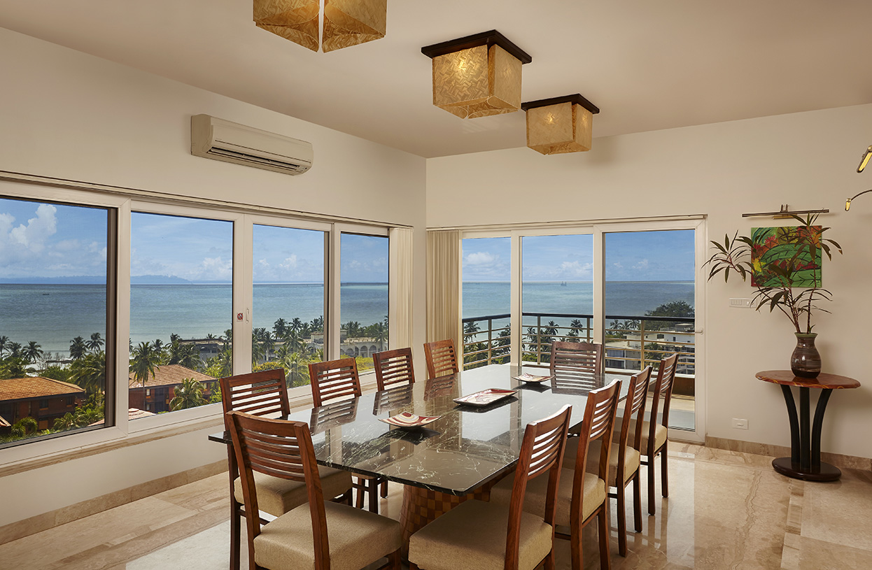 Spacious dining room with an ocean panorama, large marble dining table, and contemporary lighting at Dolphin Heights