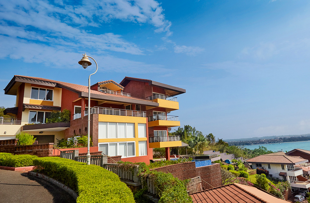 Exterior view of Dolphin Heights luxury villa featuring modern architecture, balconies, and scenic coastal surroundings