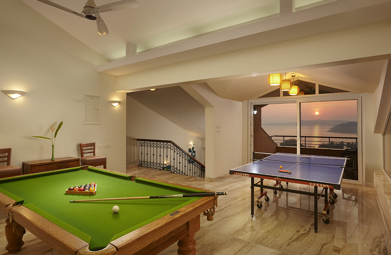 Recreation room with pool table, table tennis setup, and sunset ocean views at Dolphin Heights