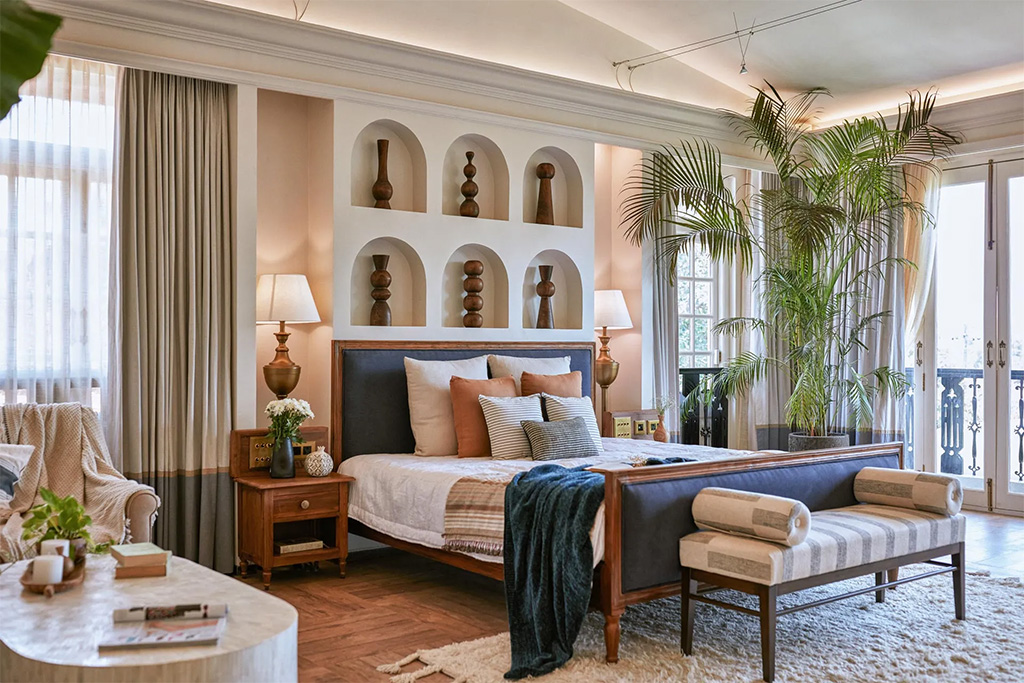 Luxury villa bedroom with a king-size bed, decorative wall art, and large windows