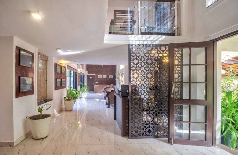 Villa interior hallway with decorative partition, seating area and plants