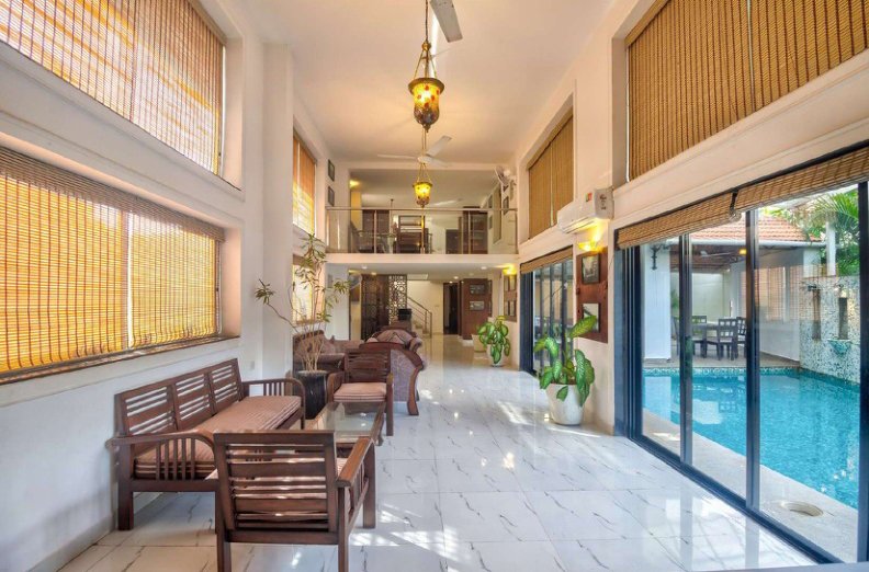 Villa interior with seating area, large windows and pool view