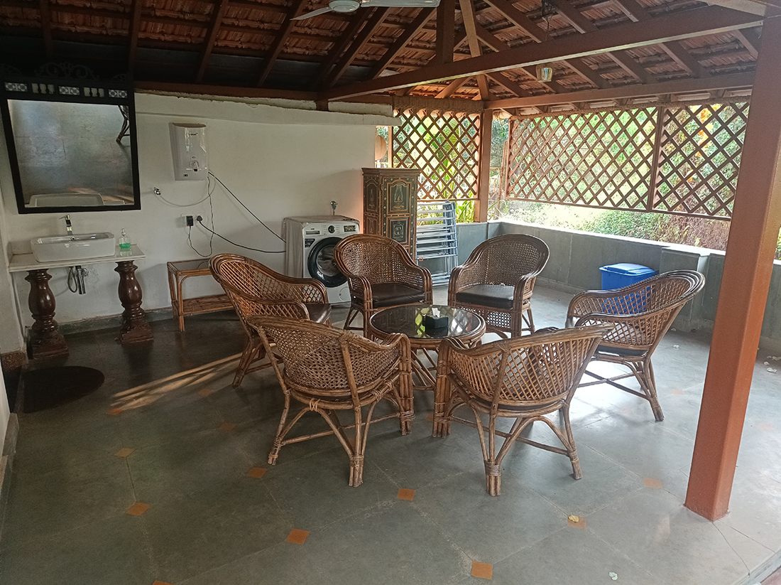 Semi-outdoor seating area with wicker chairs and washing machine