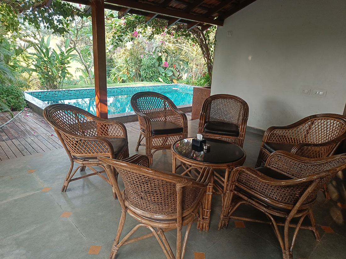 Outdoor patio with wicker chairs and table near pool