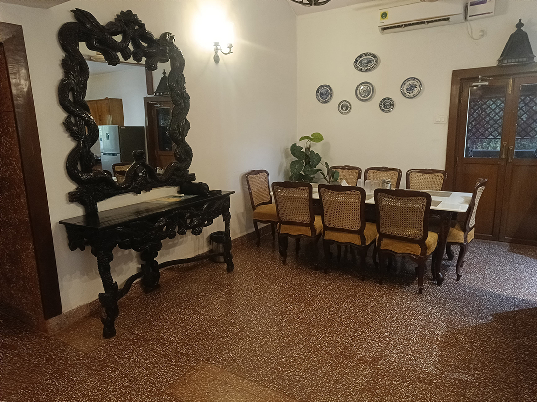 Dining area with a large mirror, ornate table, and eight chairs.