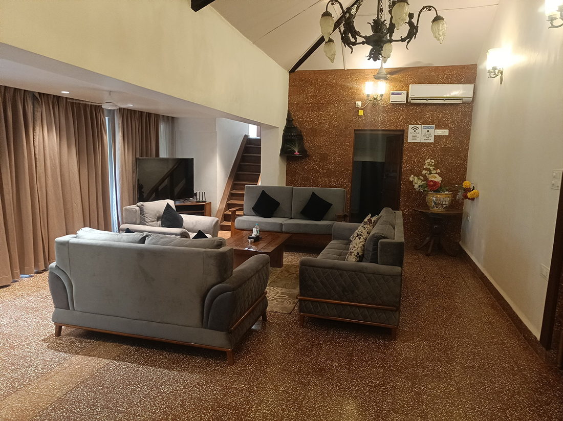 Spacious living hall with sofas, TV, and chandelier