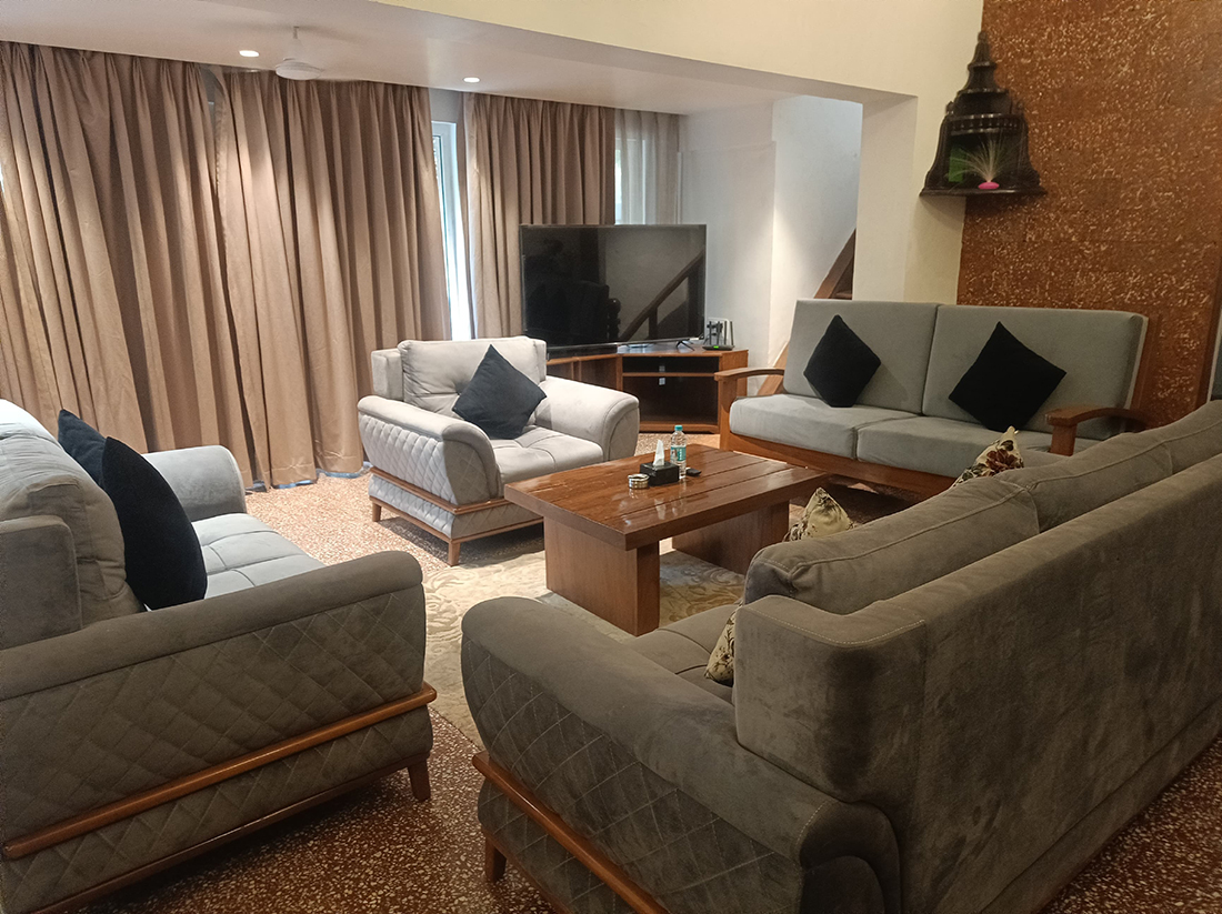 Living room with grey sofas, wooden table, and TV.