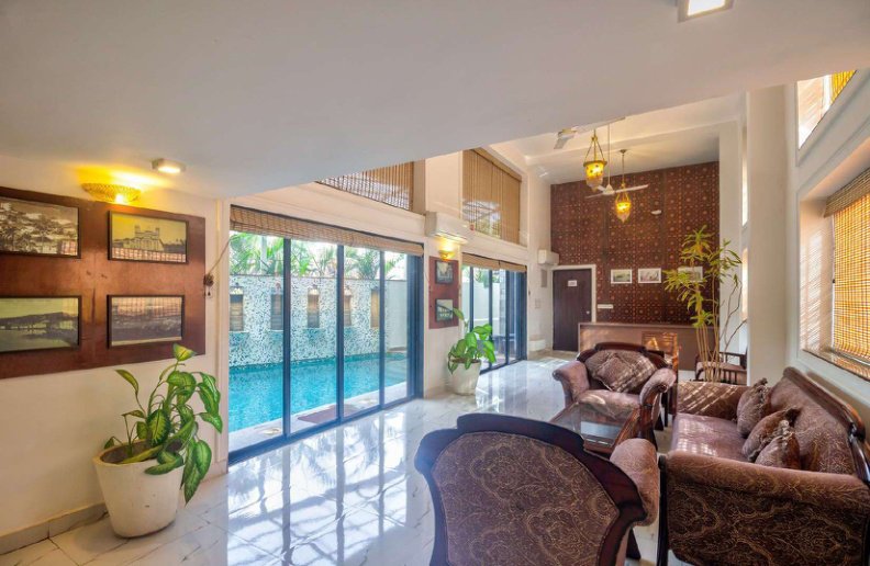 Villa living room with seating area and pool view through glass doors