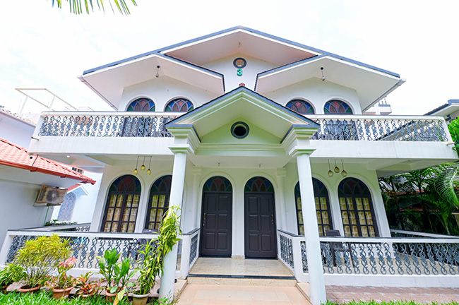 Front view of a two-storey luxury villa with balconies and entrance porch