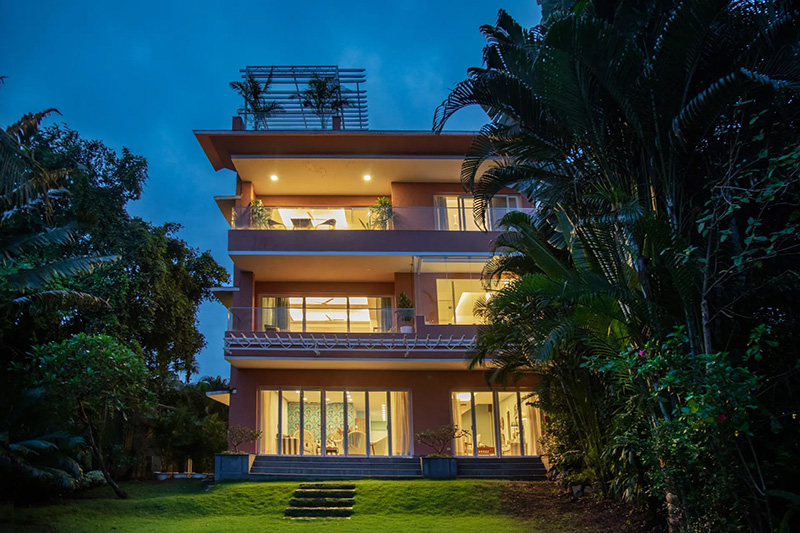 Luxury villa exterior with illuminated balconies at night