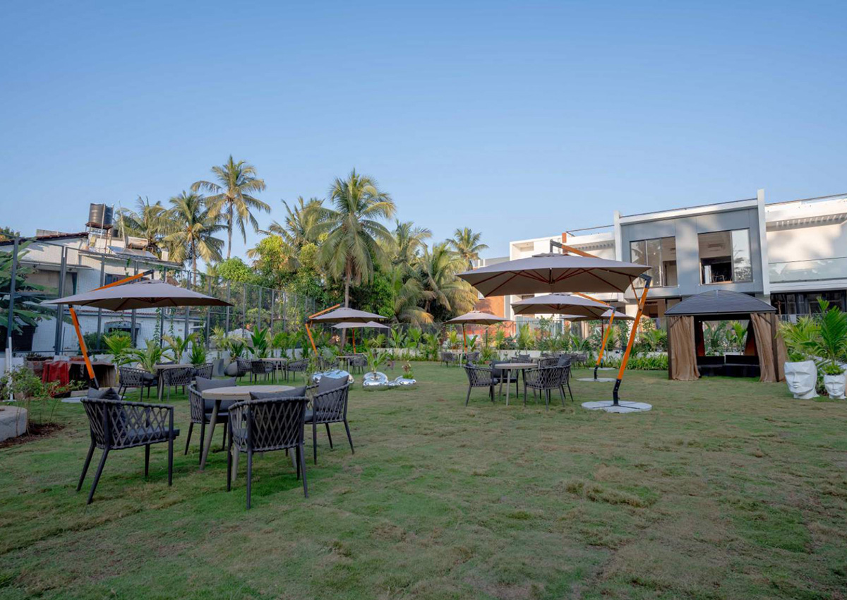 Luxury villa lawn with outdoor seating and umbrellas surrounded by palm trees