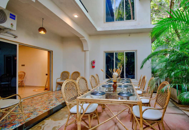 Spacious villa patio dining area with tropical plants and seating