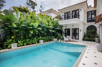 Luxury white villa with a private swimming pool and lush tropical garden