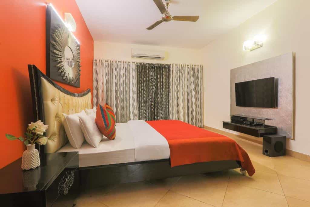 Modern villa bedroom with king bed, TV and air conditioning