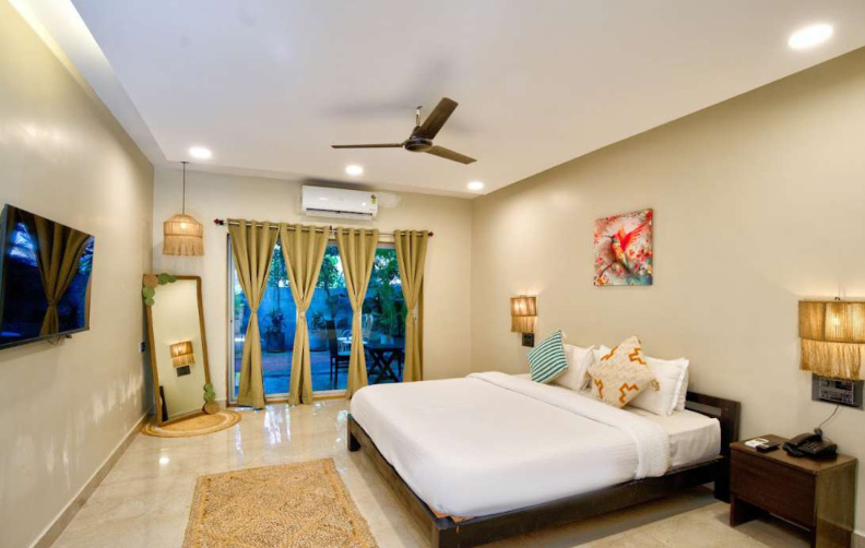 Deluxe bedroom interior with TV and balcony in Morjim villa
