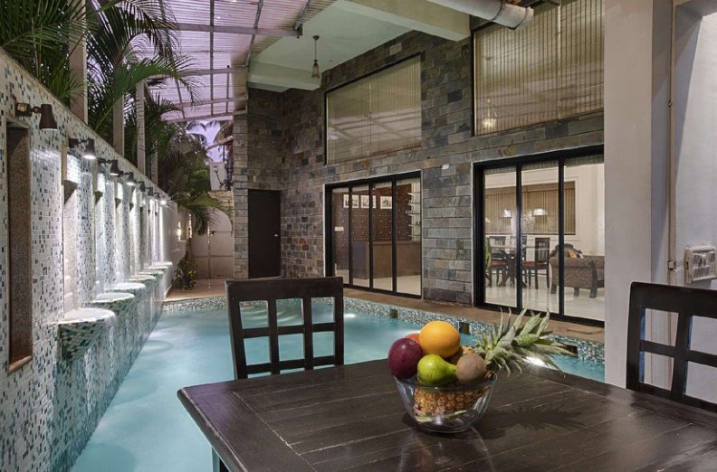 Villa swimming pool with outdoor dining table and stone wall