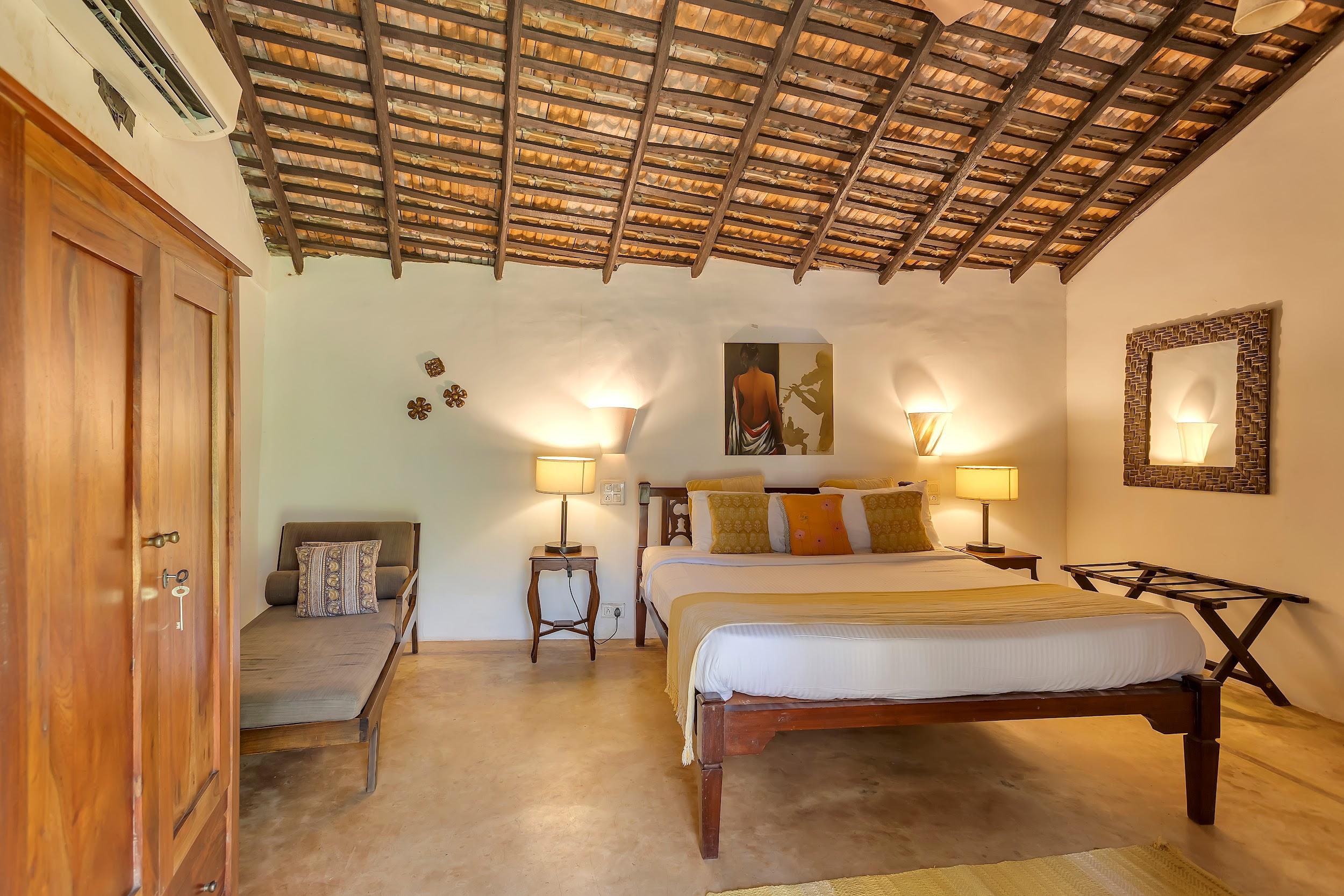 Bedroom with sloped wooden ceiling, AC unit, and wooden wardrobe next to the bed