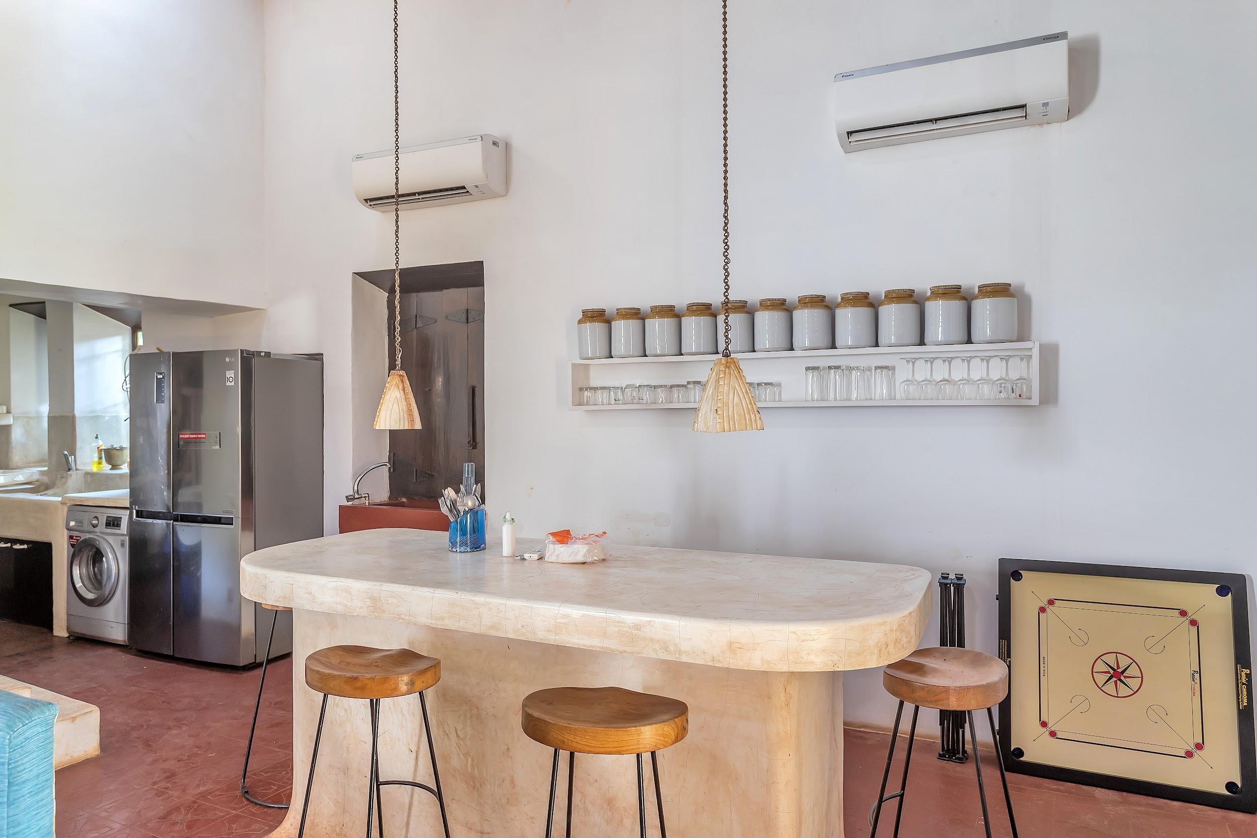 Kitchen/Dining area with a large island, stools, dual refrigerators, and two hanging pendant lights