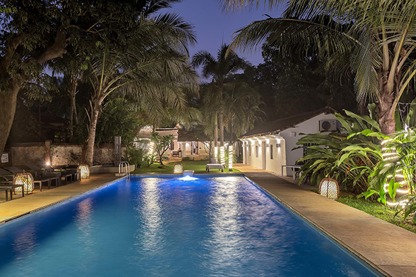 Private swimming pool with tropical garden and villa at night