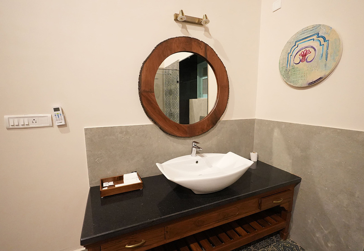 Modern bathroom with vessel sink and round mirror in a Goa villa
