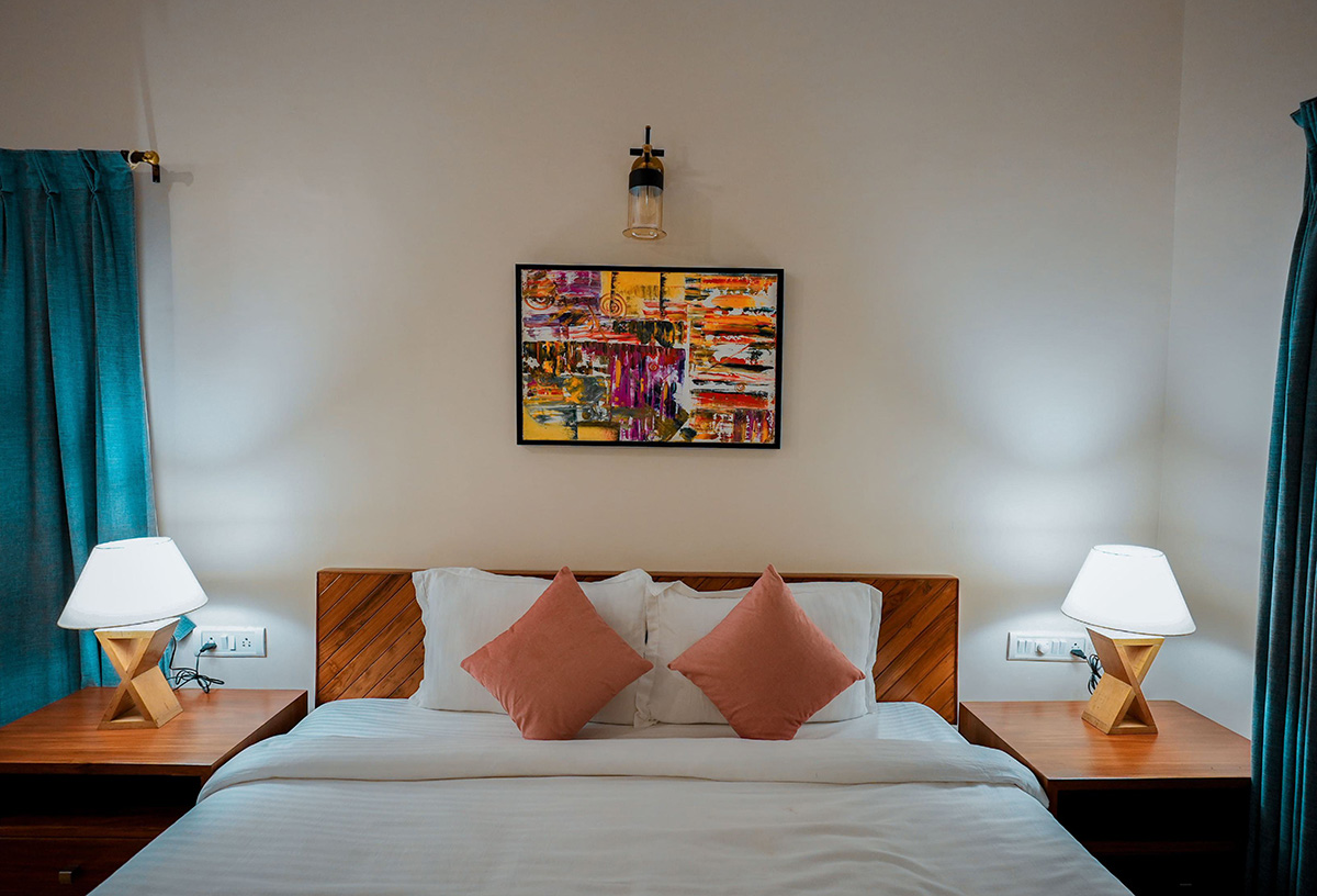 Bright bedroom with artwork and sunlight streaming through windows