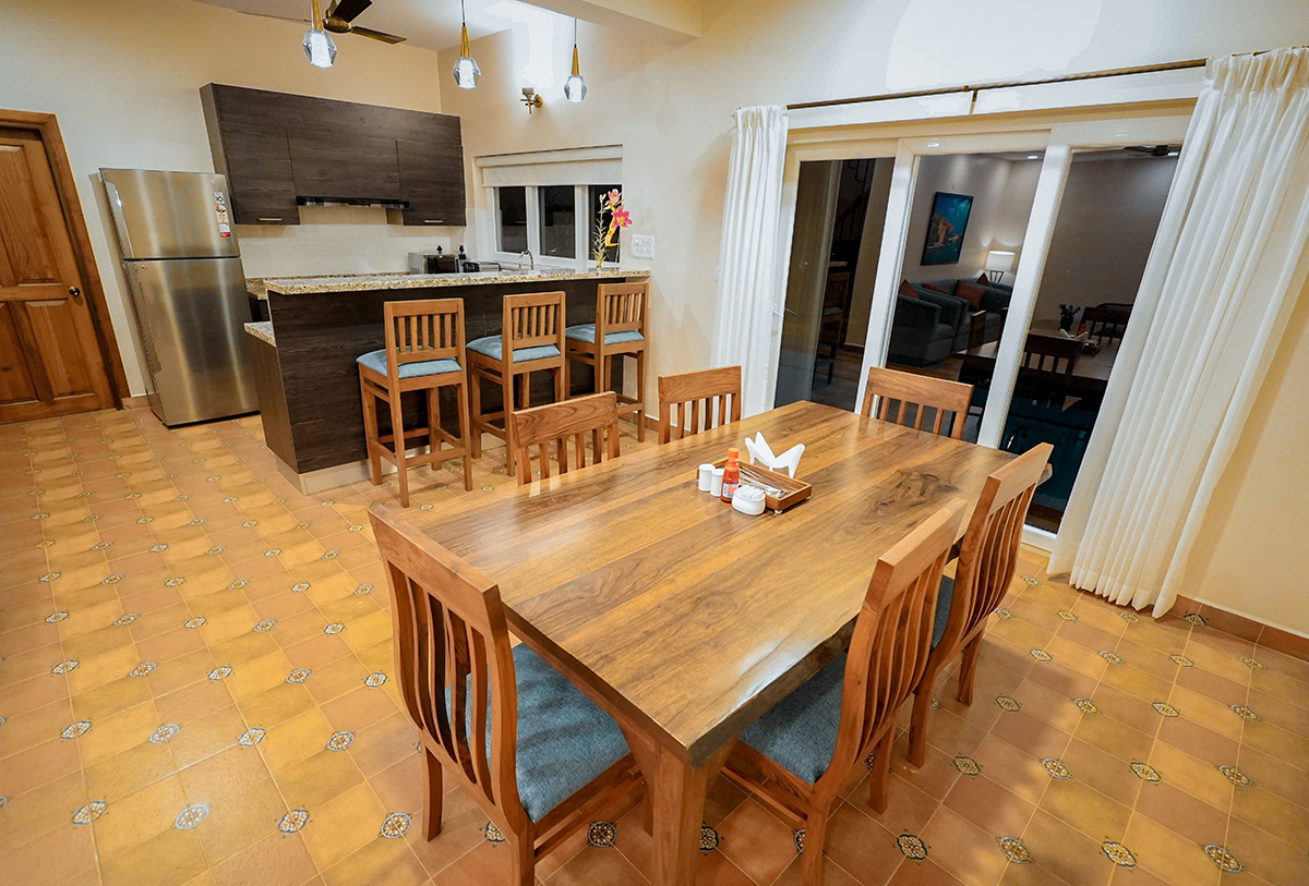 Dining area with wooden table and open kitchen layout