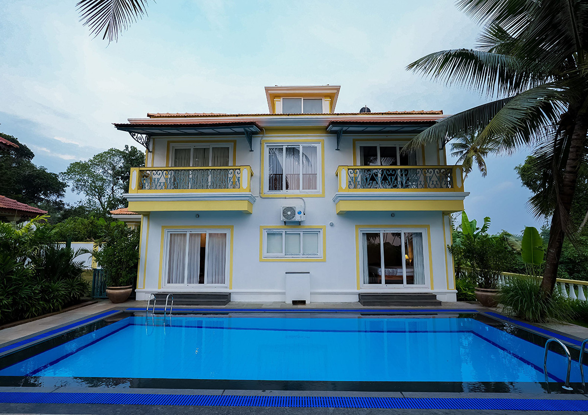 Villa exterior with swimming pool surrounded by palm trees