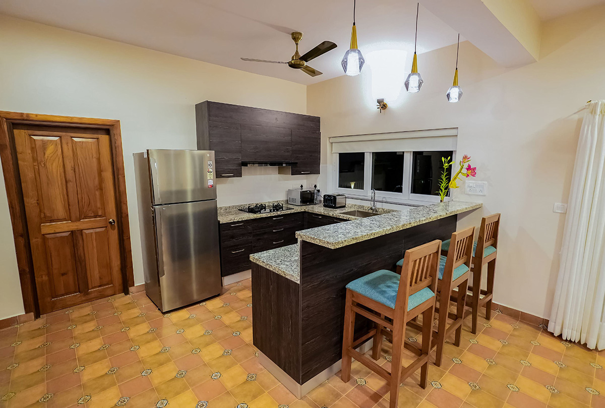 Modern kitchen featuring granite breakfast bar and pendant lights.