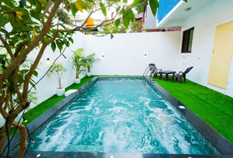 Relax in a private outdoor pool surrounded by greenery and cozy seating