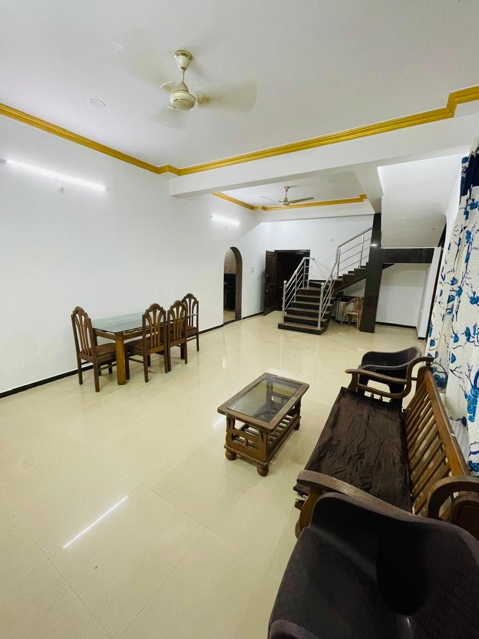 View of the living hall with dining table and staircase