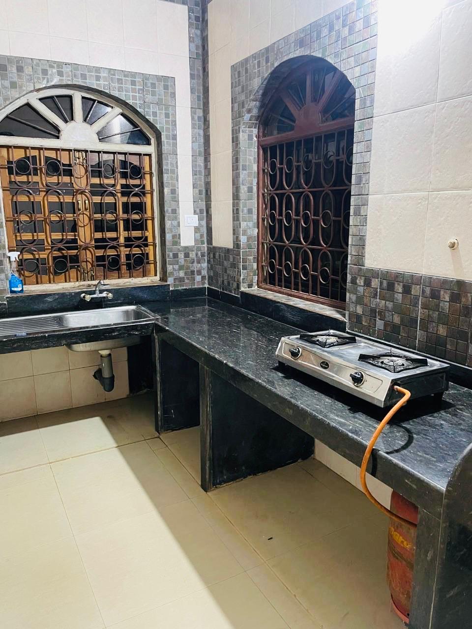 Kitchen with black counters and arched windows