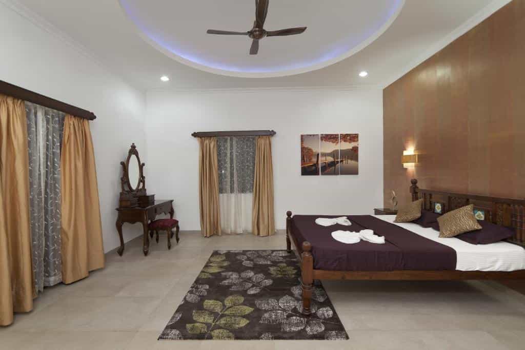 Spacious villa bedroom with wooden bed and dressing table