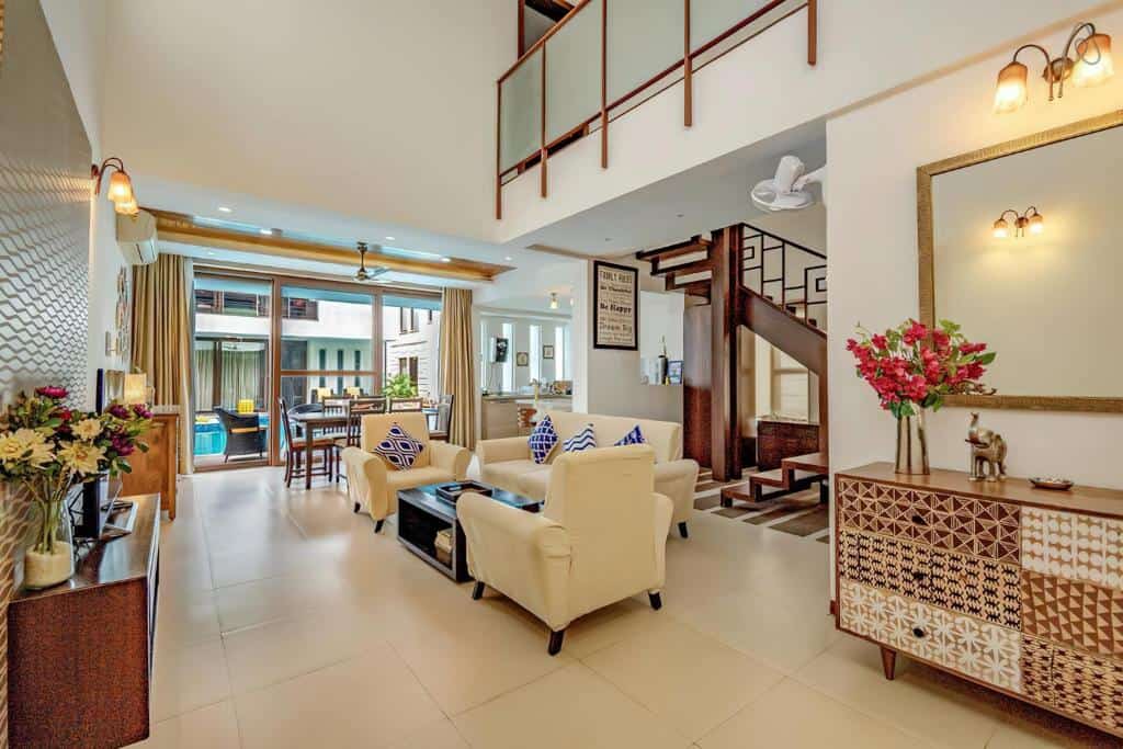 Spacious villa living room with sofa seating and staircase