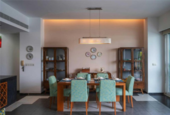 Dining room with a table, teal chairs, and cabinets