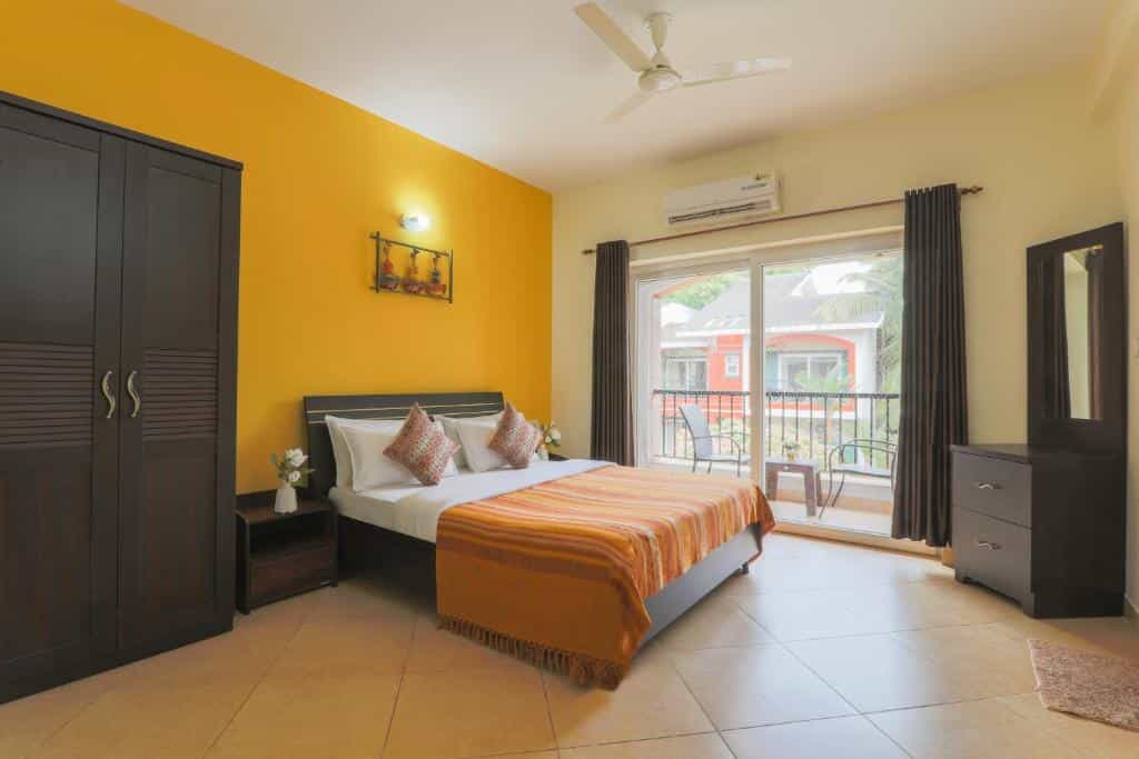 Bedroom with a double bed and balcony overlooking the villa