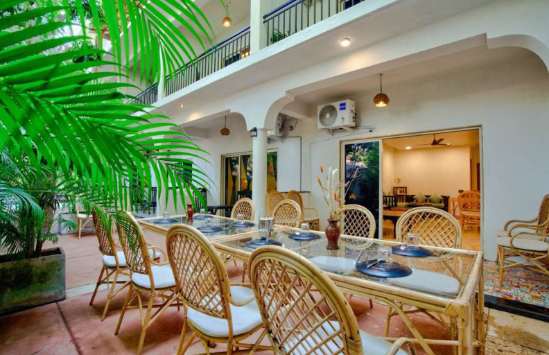 Courtyard outdoor dining area with rattan furniture in Goa villa