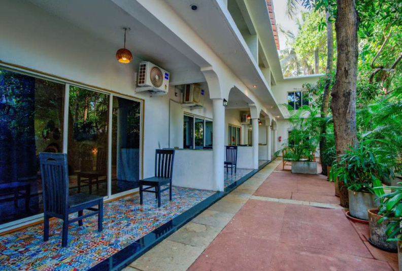 Villa courtyard walkway with tropical plants and guest room entrances