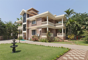 Two-story house with balconies, a lawn, and a fountain at De Mandarin Beach Villas