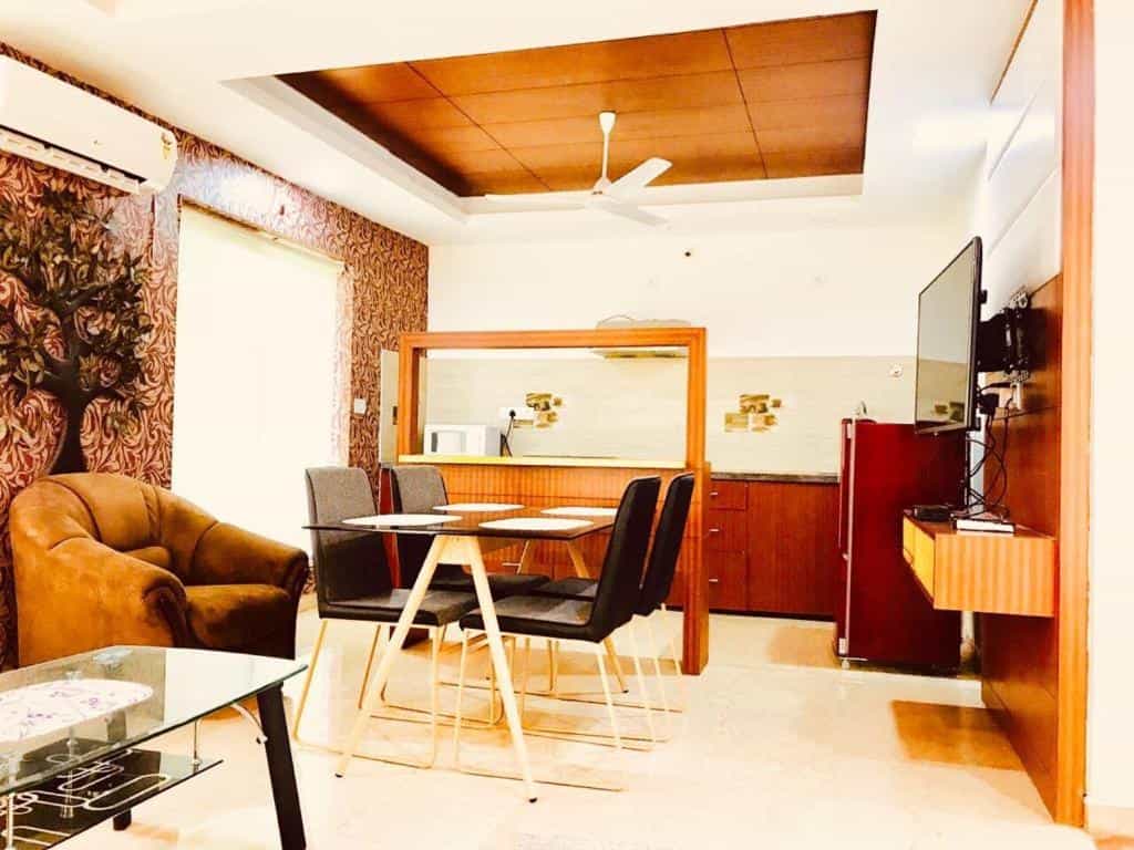 Villa living room with dining table, sofa, TV, and kitchenette