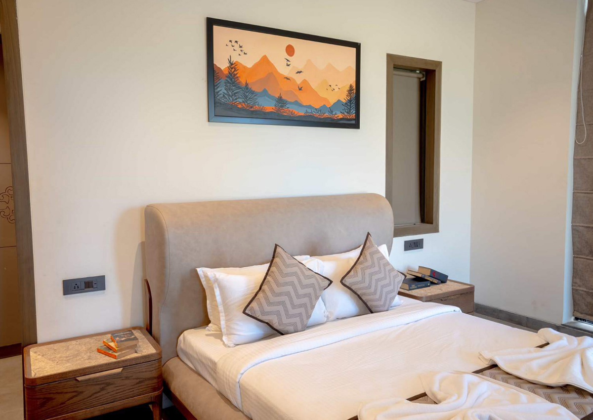 Bedside close-up in beige-toned suite with marble-top table and decorative accessories