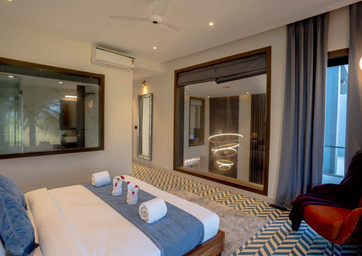 Elegant bedroom in blue theme with interior glass panel and patterned flooring